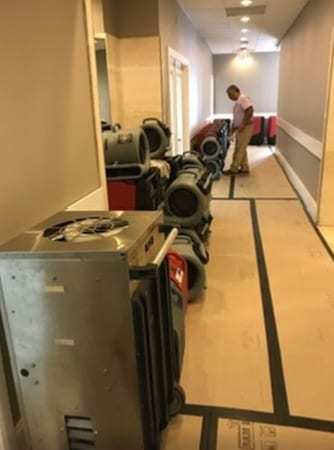 Hotel corridor with dehumidifiers and air movers